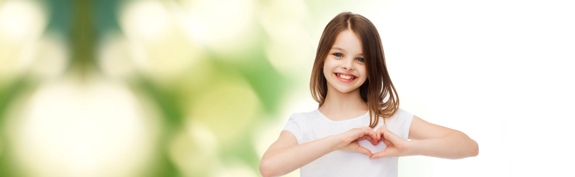 smiling little girl making heart-shape gesture